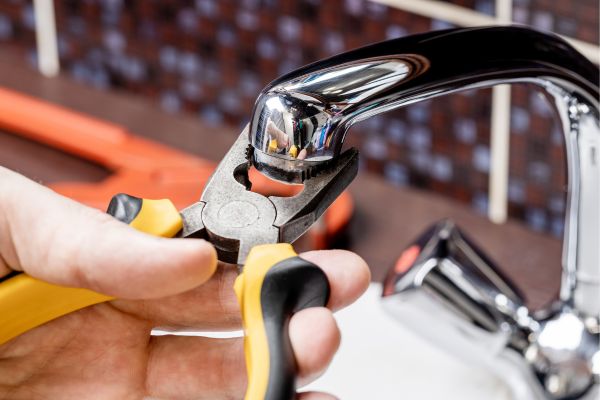 Worker performing plumbing repair on a faucet